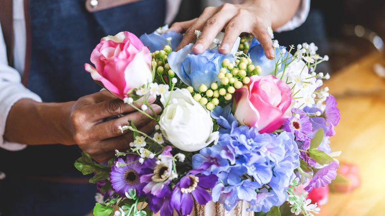 Person arranging faux flowers