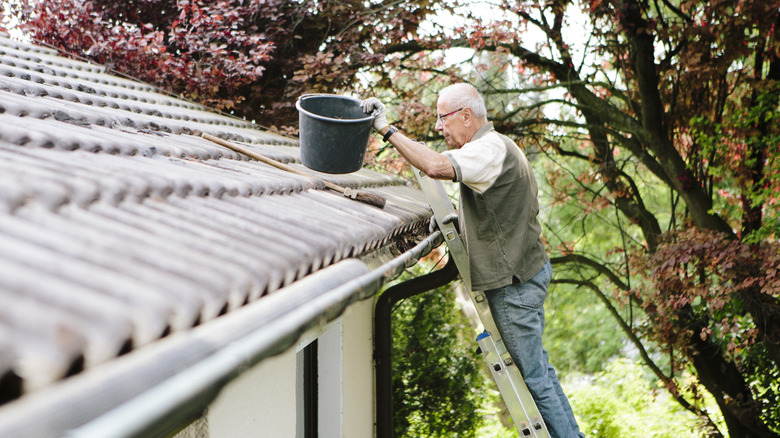 A man trying to clean stained asphalt roof shingles