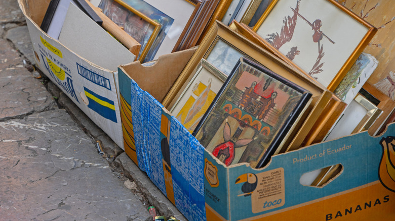 Boxes full of paintings and prints at thrift store.