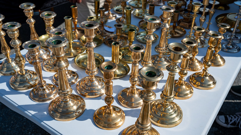Various vintage-style gold candlestick holders sitting on a table