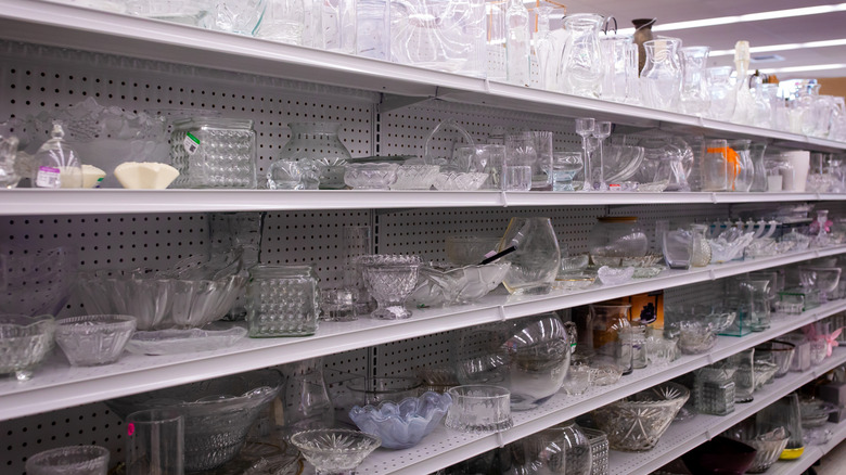 The shelves of a thrift store full of glassware.