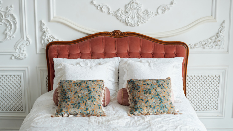 Red vintage tufted headboard with wood frame and classic linens.