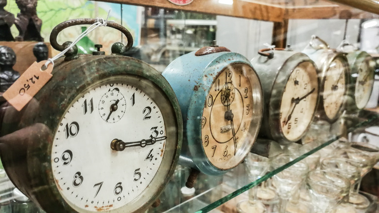 Five vintage clocks in a case at an antique store