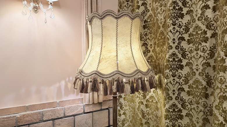 A close-up of a vintage floor lamp with tassels