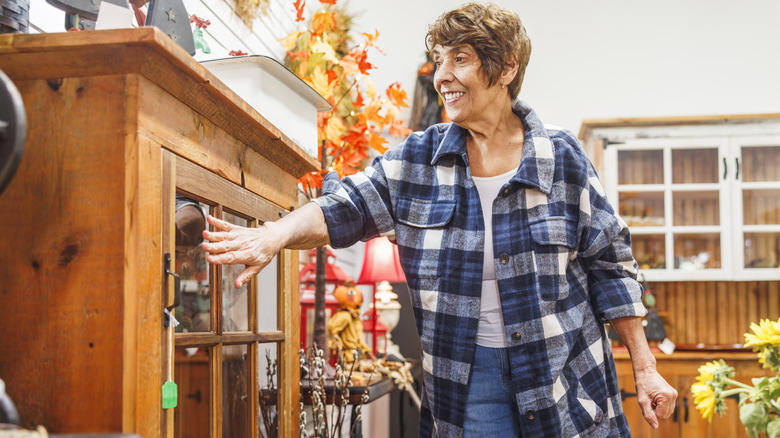 A woman shopping for a cabinet in a secondhand store