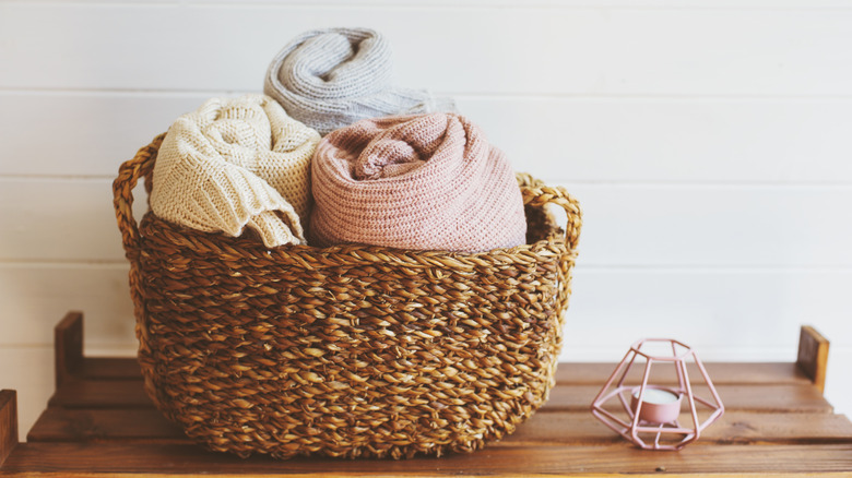Wicker basket with rolled-up blankets inside