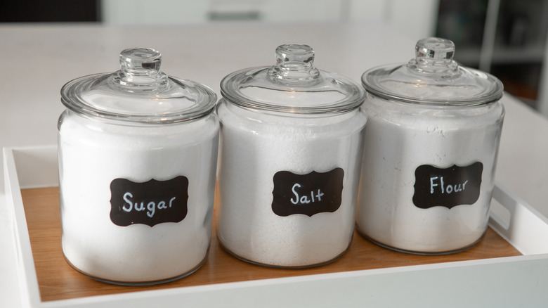 Clear glass jars with sugar, salt, and flour