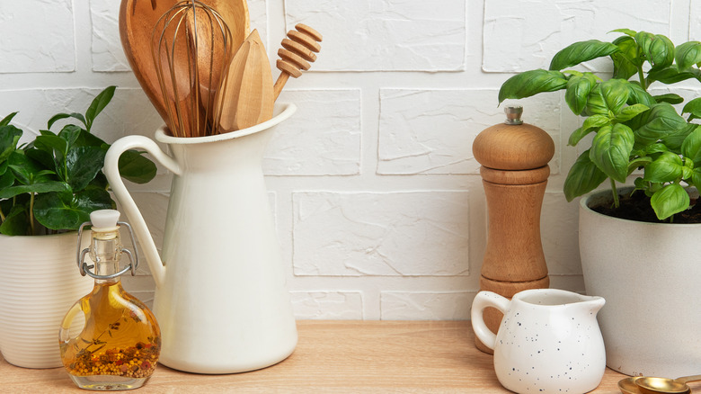 white farmhouse pitcher full of wood kitchen utensils
