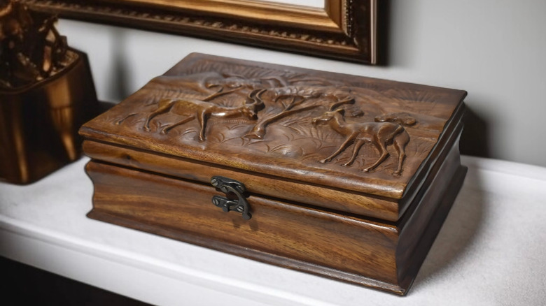 Wood storage box with ornate carved lid