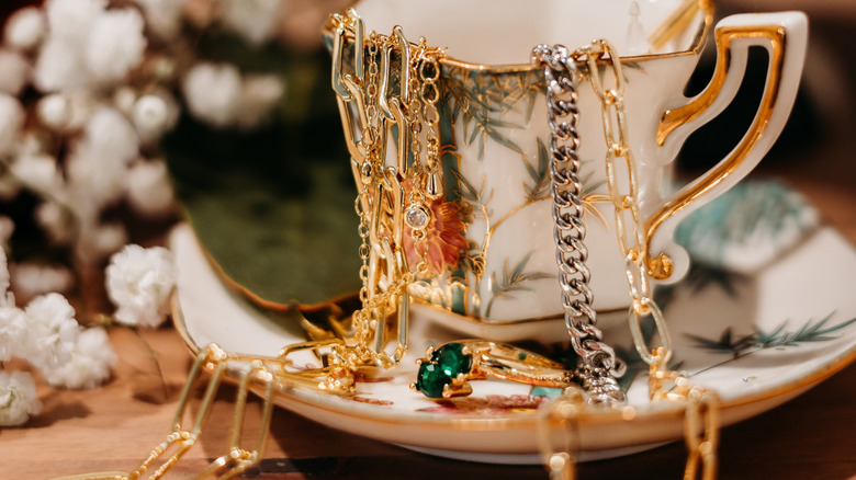 antique white and gold teacup with jewelry inside