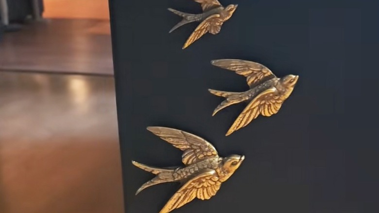 Brass bird sculptures attached to a wall