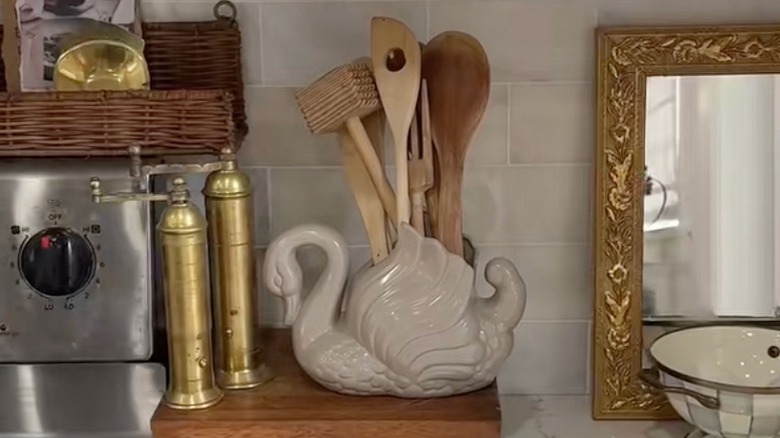 Closeup of a thrifted swan planter with utensils