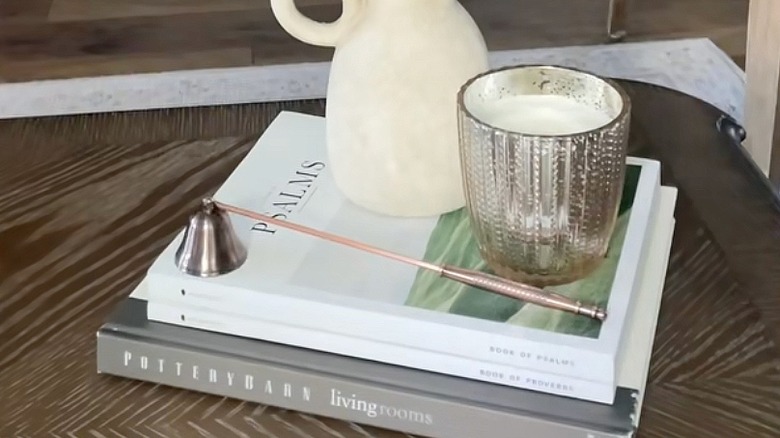 Stacked hardcover books on a table underneath home decor