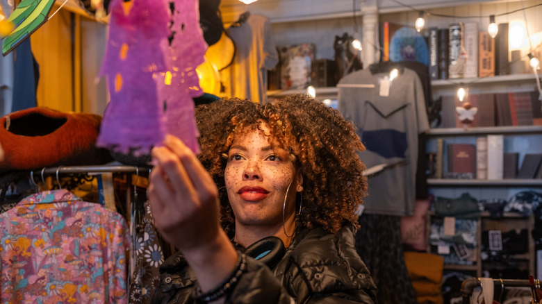 Closeup of a woman looking at fabric in a thrift store