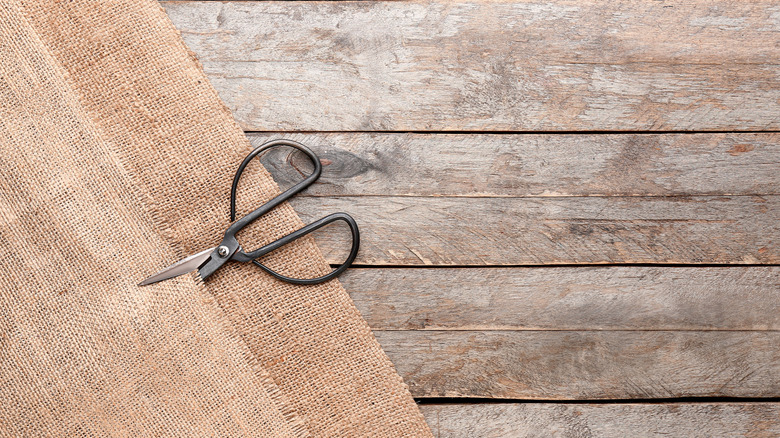 Close up of burlap fabric with a pair of scissors