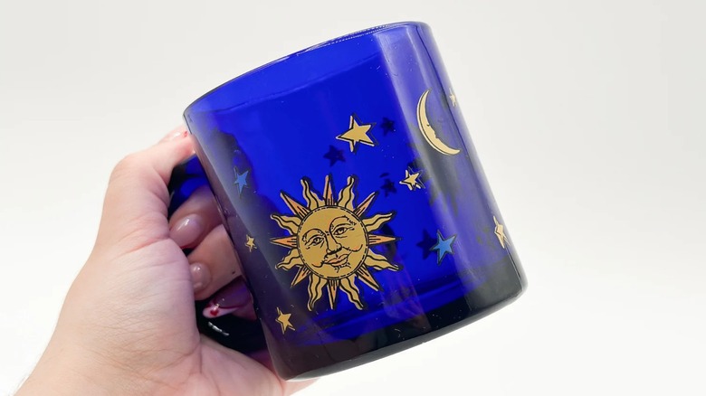 hand holding up libbey blue celestial mug with gold painted moon and stars
