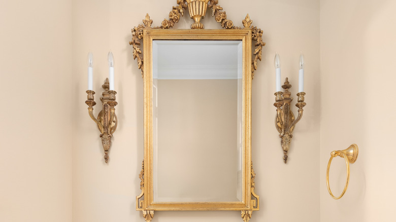 Vintage wall sconces on either side of bathroom mirror