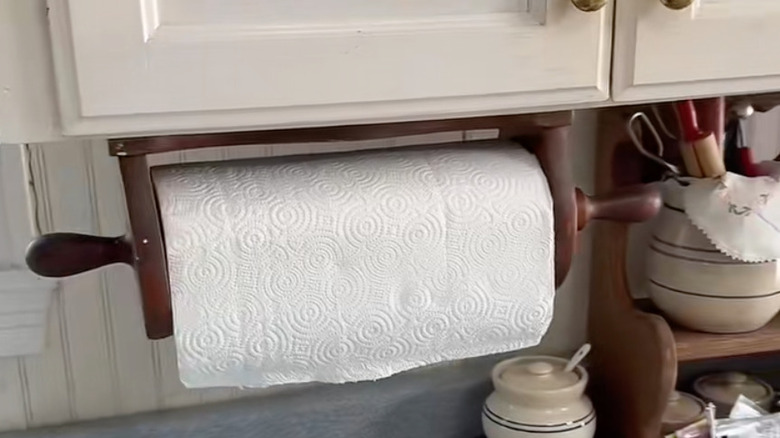 vintage wooden paper towel holder mounted under a cabinet