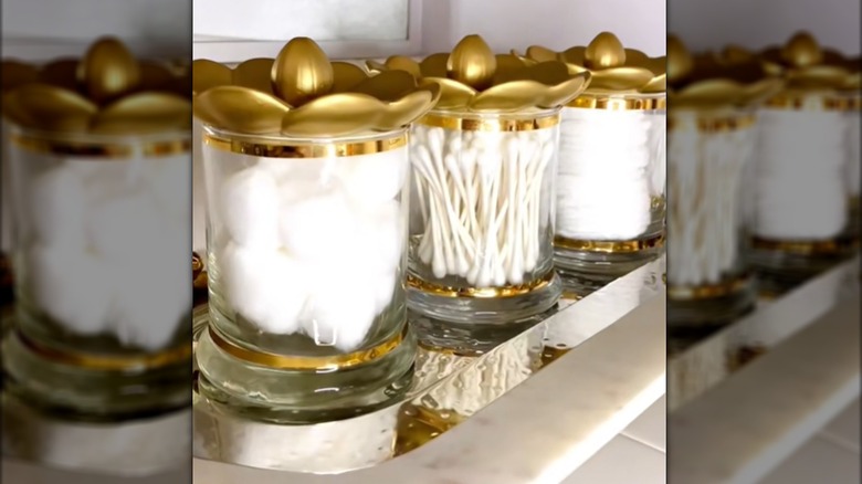 Dollar Tree candle holders and incense trays are decorated to become bathroom storage.