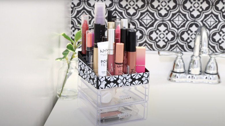 A DIY makeup organizers with drawers and a lipstick rack sit on a clean bathroom countertop.