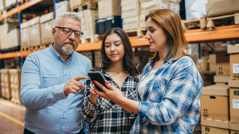 warehouse people looking at phone