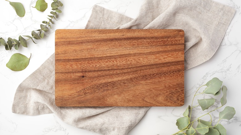 wooden cutting board on linens