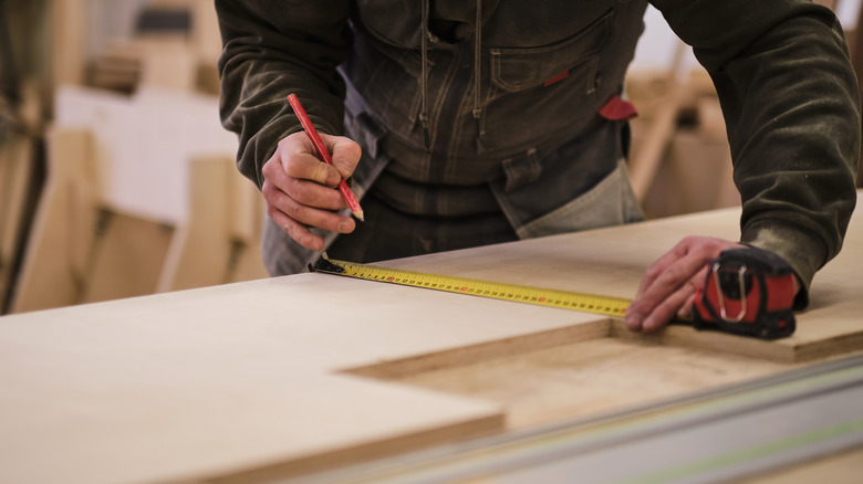 men measuring wood lumber 