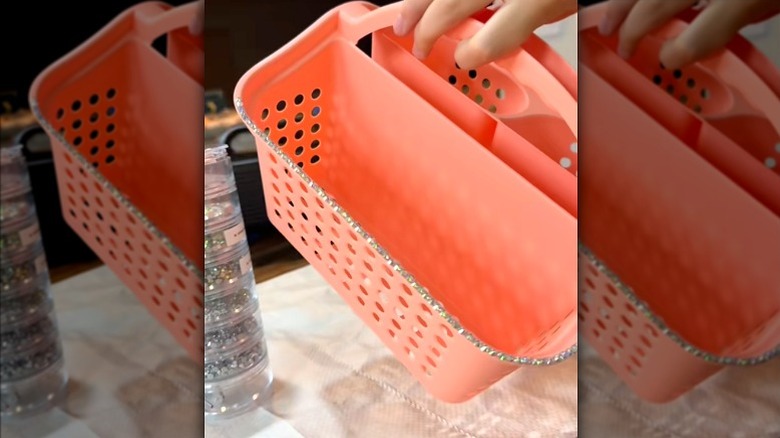 person applying decorative gem lining to pink house caddy