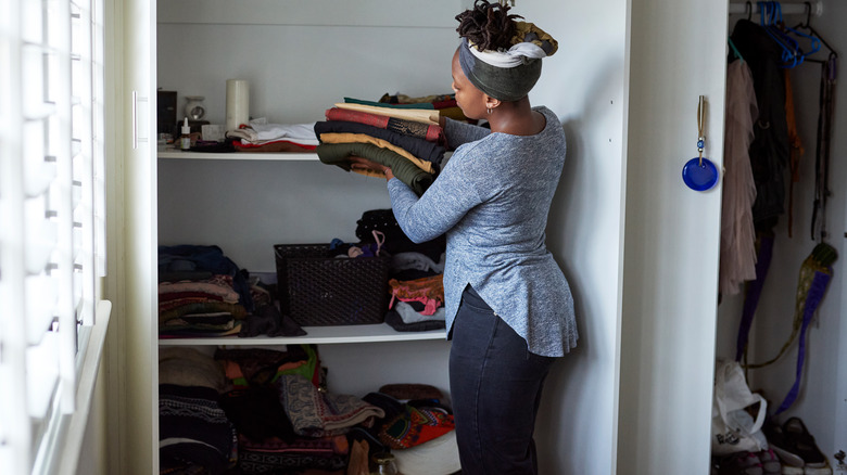 African-American woman emptying closet