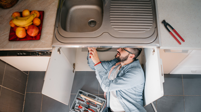 man installing undermount sink