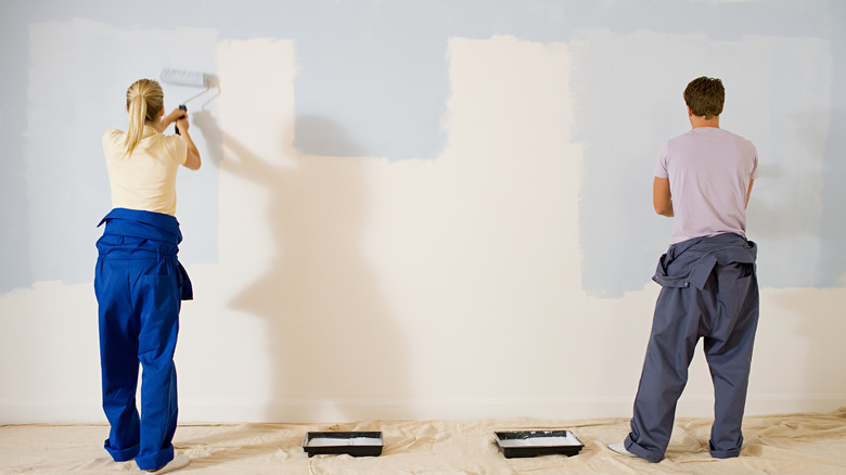 A couple painting a wall