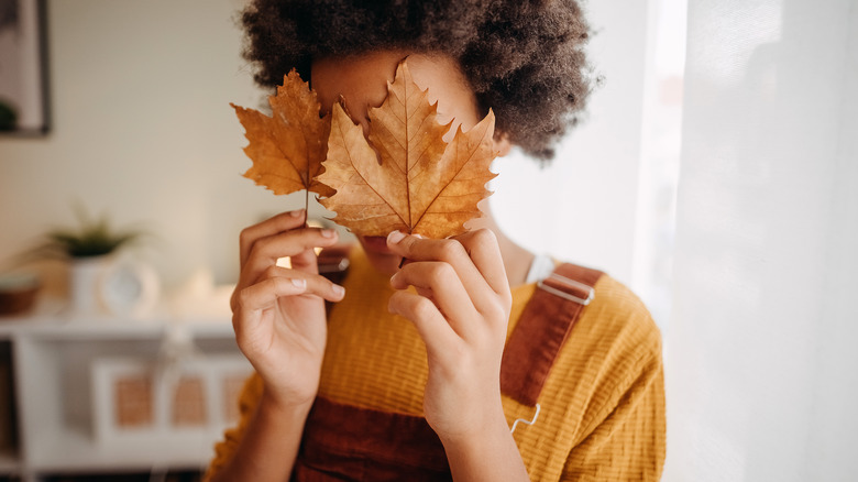 woman holding leaves