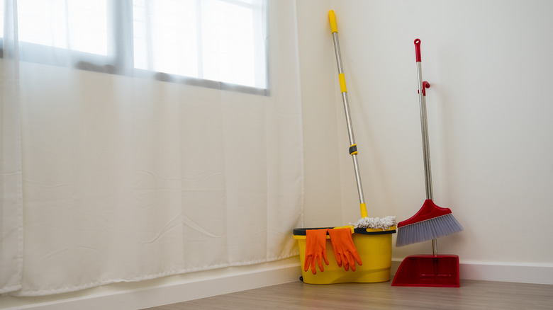 broom and mop against wall