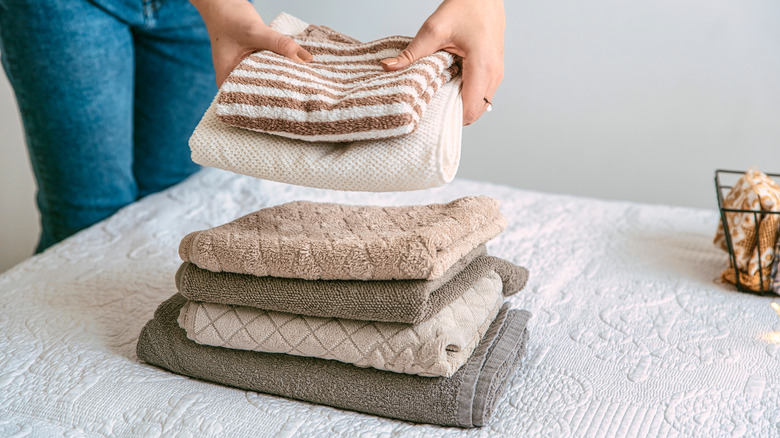 person folding brown washcloths