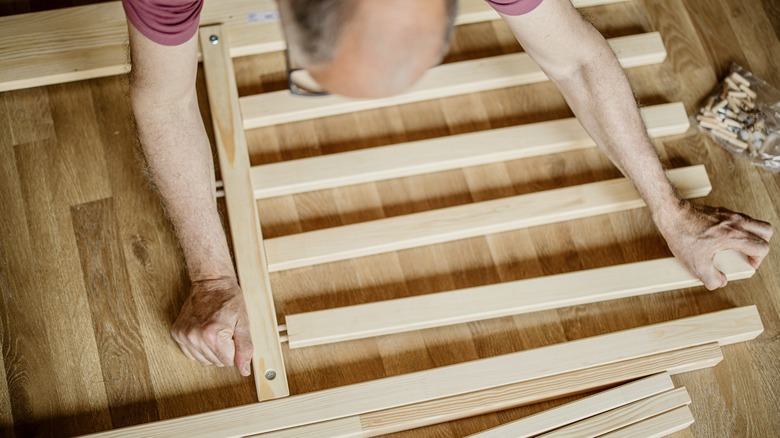 man building IKEA bed