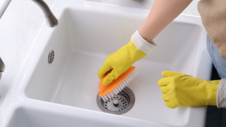 Person cleaning drain stopper