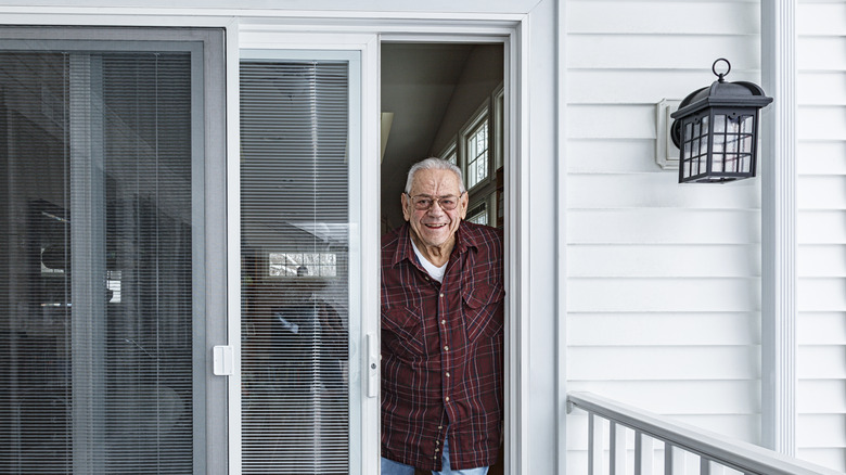 Man looking out a sliding glass door