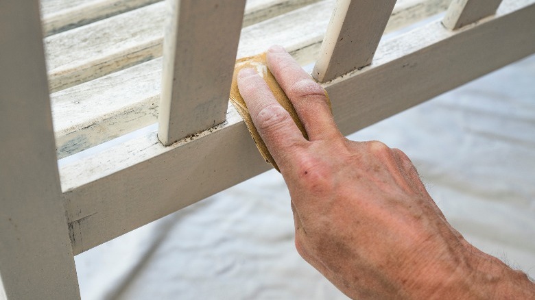 person sanding a rail