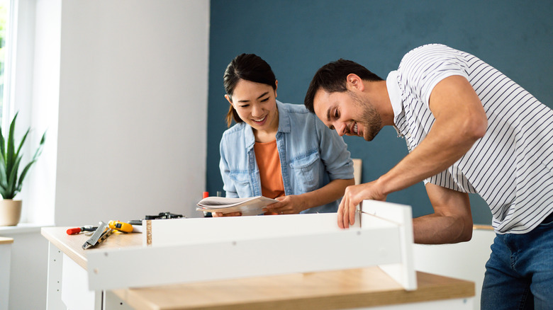 Couple arranging furniture