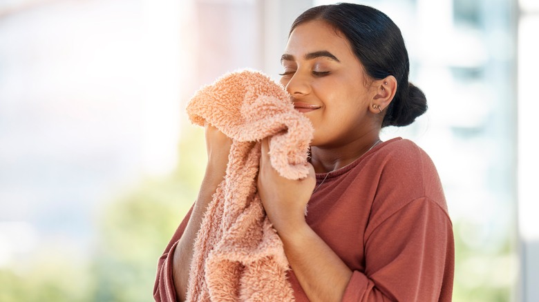 Woman smells clean laundry