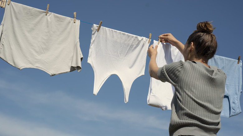 person hanging clothes outside