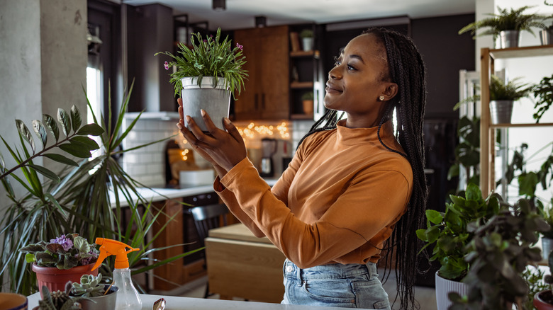 woman smiling at houseplant