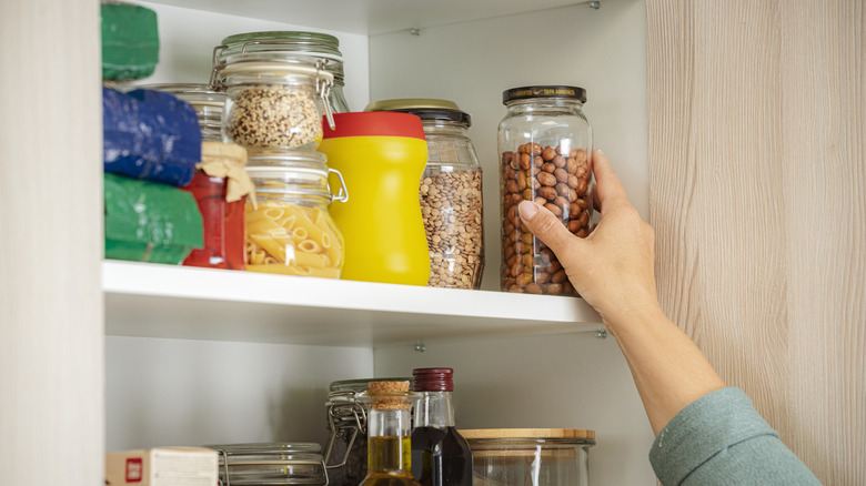 Hand grabbing jar off shelf