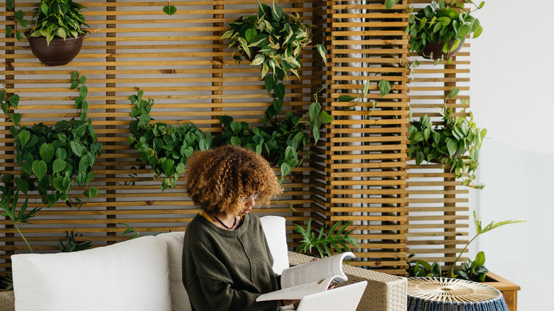 woman reading in plant filled room