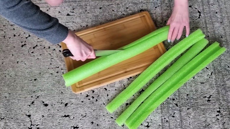 woman cutting pool noodles with knife