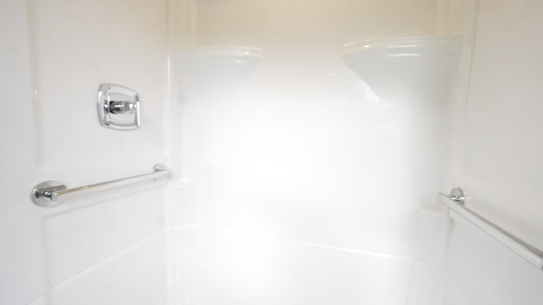 A shower made of fiberglass and including silver fixtures