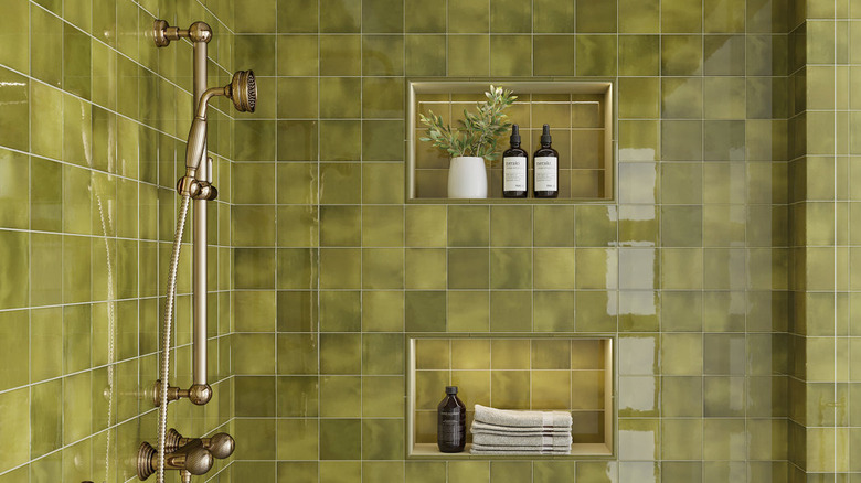 A modern shower covered in green square tiles.