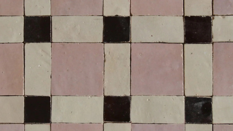 Moroccan zellige mosaic tiles in pink, ivory, and dark brown.