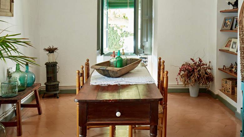 A dining room with terracotta tile floors.