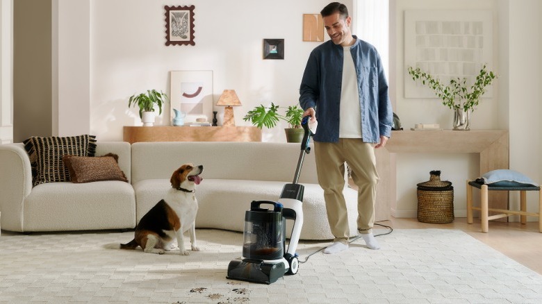 A man cleaning a white rug with a carpet cleaner